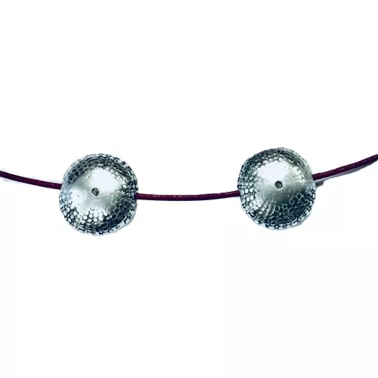 Intercalaire pastille et traversant forme aplatie